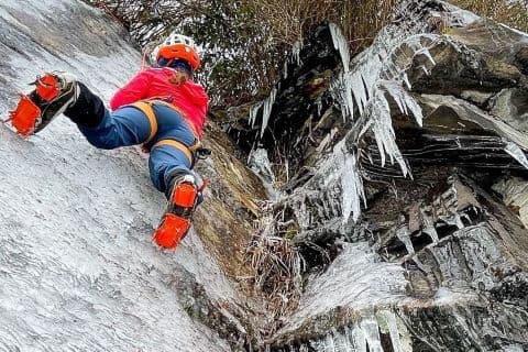 bottom up view of Anna Marie Alewine ice climbing in North Carolina