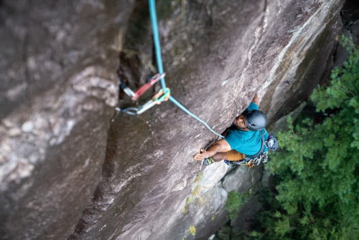 Black male looks upward while multipitch rock climbing on Laurel Knob